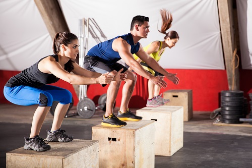 group of people jumping onto box gym