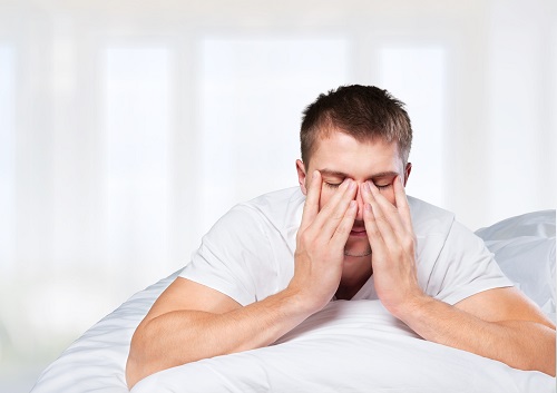 man waking up in white bed