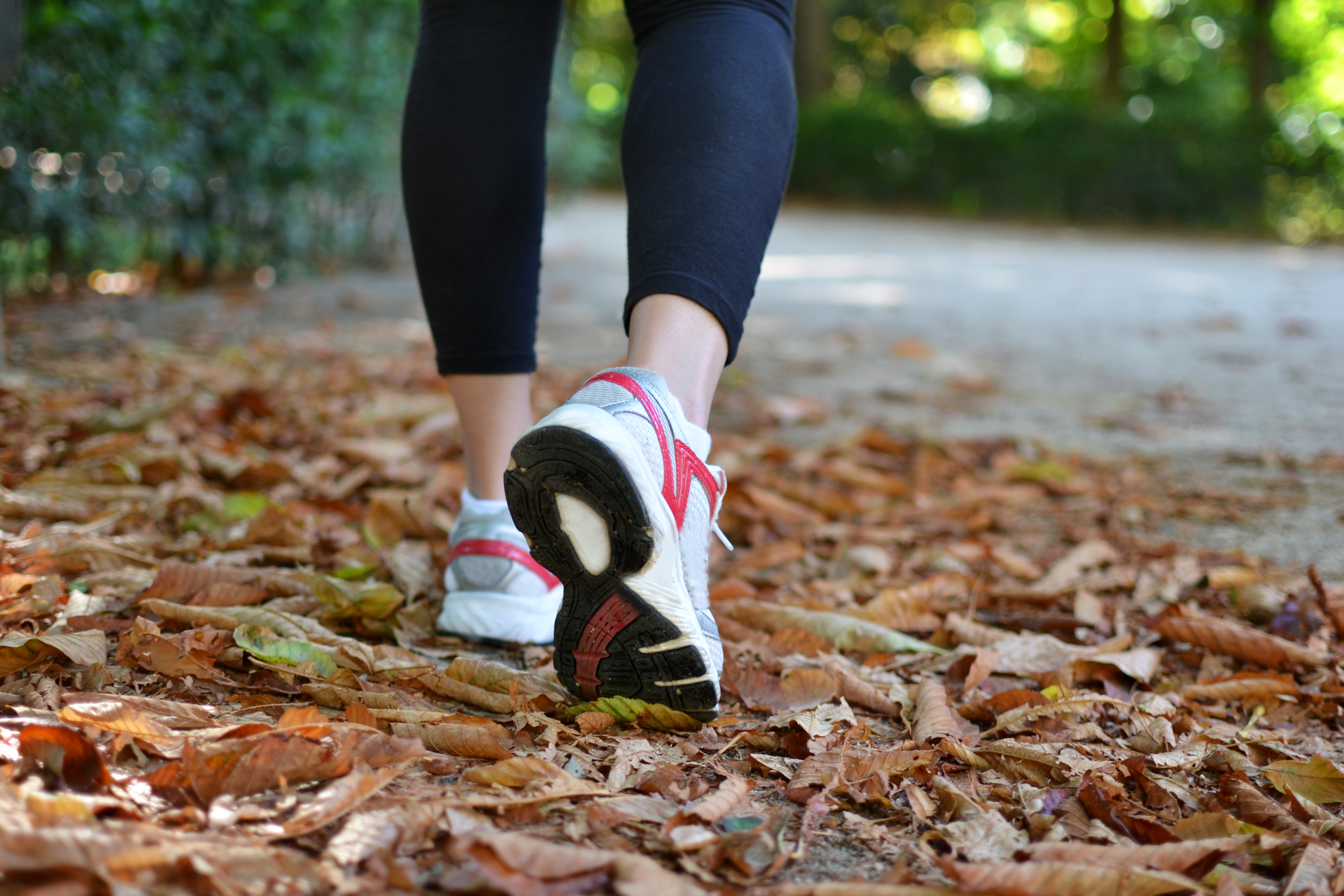 Women wearing running shoes in autumn leaves