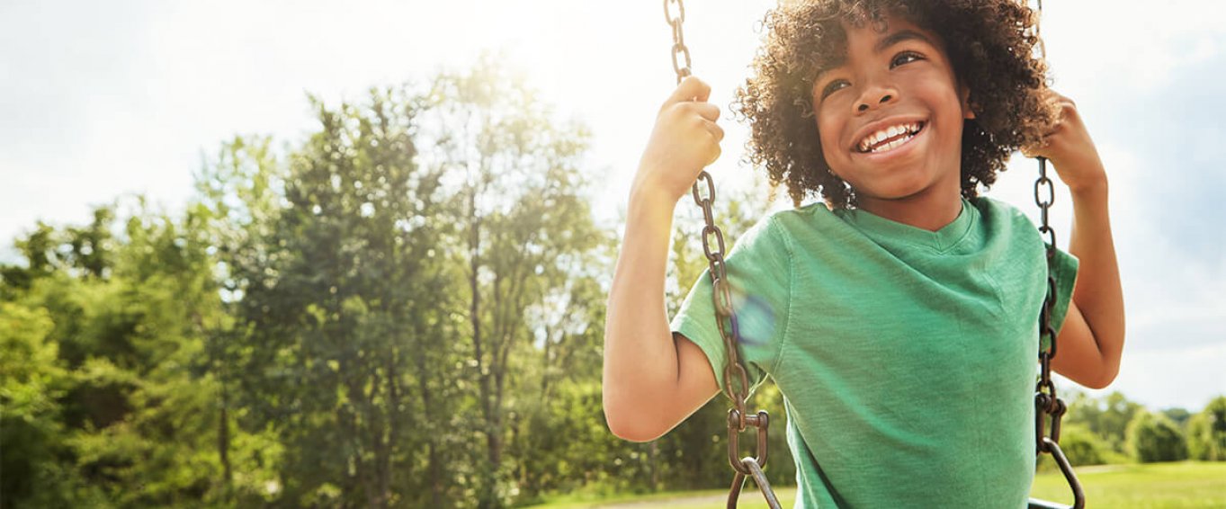 Young Boy Sitting on a Swing Young Boy Sitting on a Swing