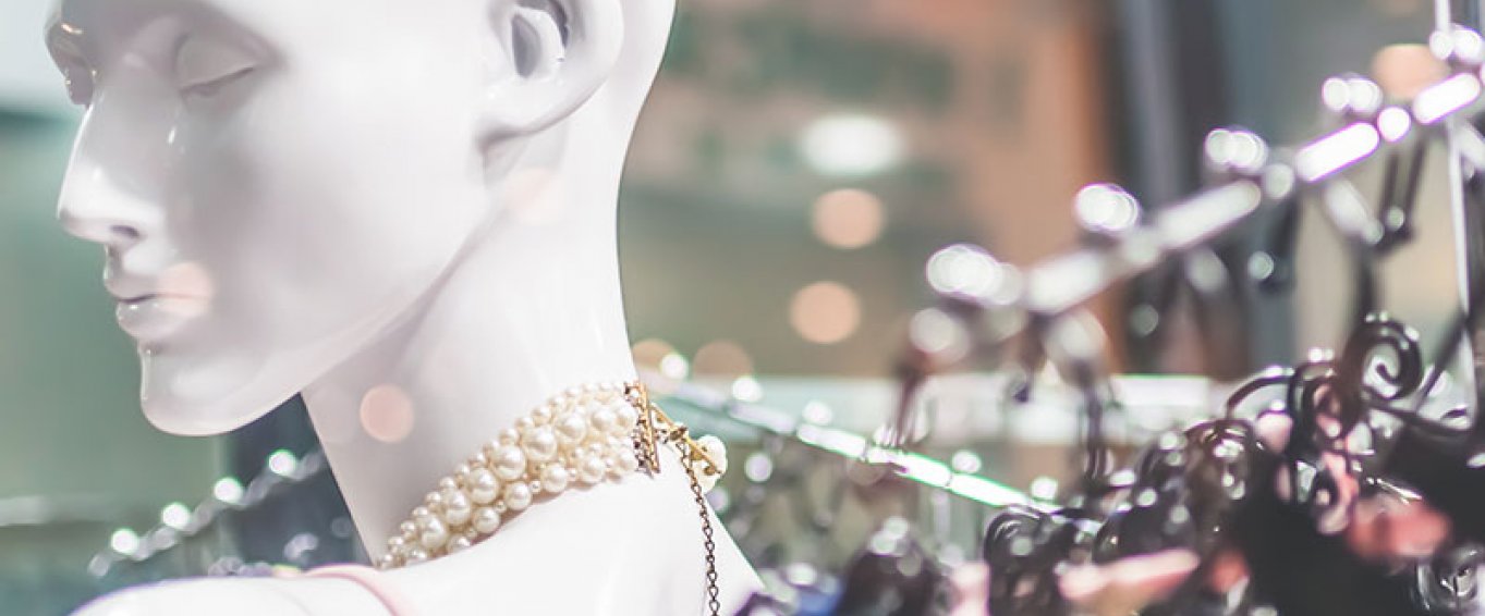 Mannequin in front of dresses