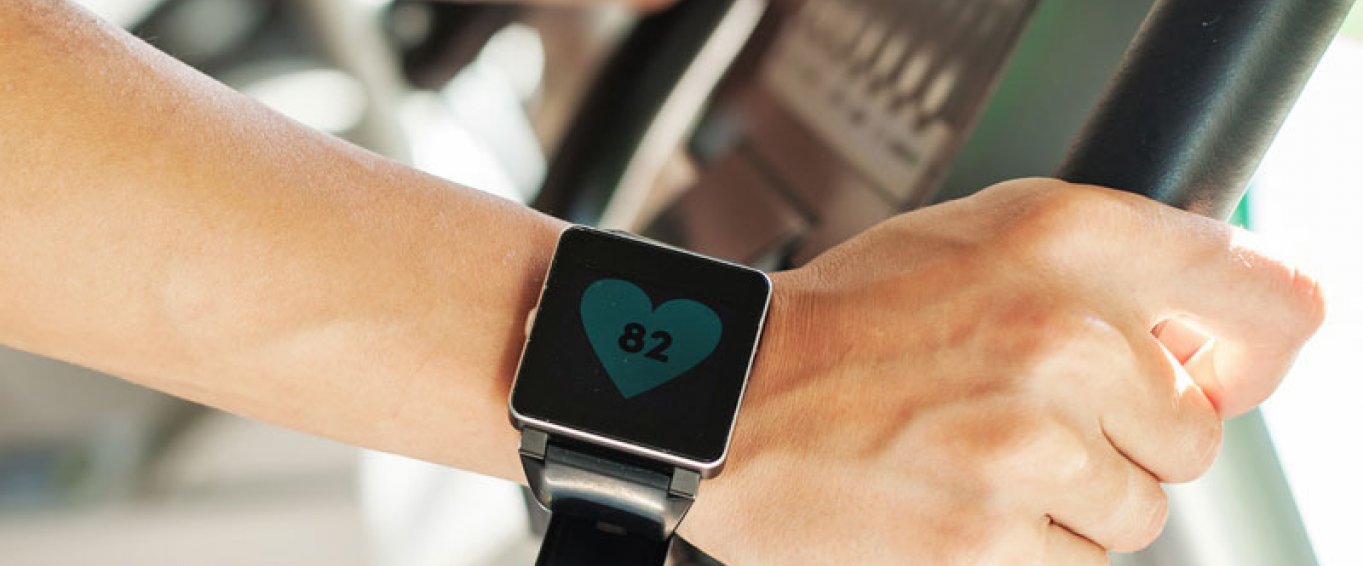 Man with a fitness tracker on an exercise bike