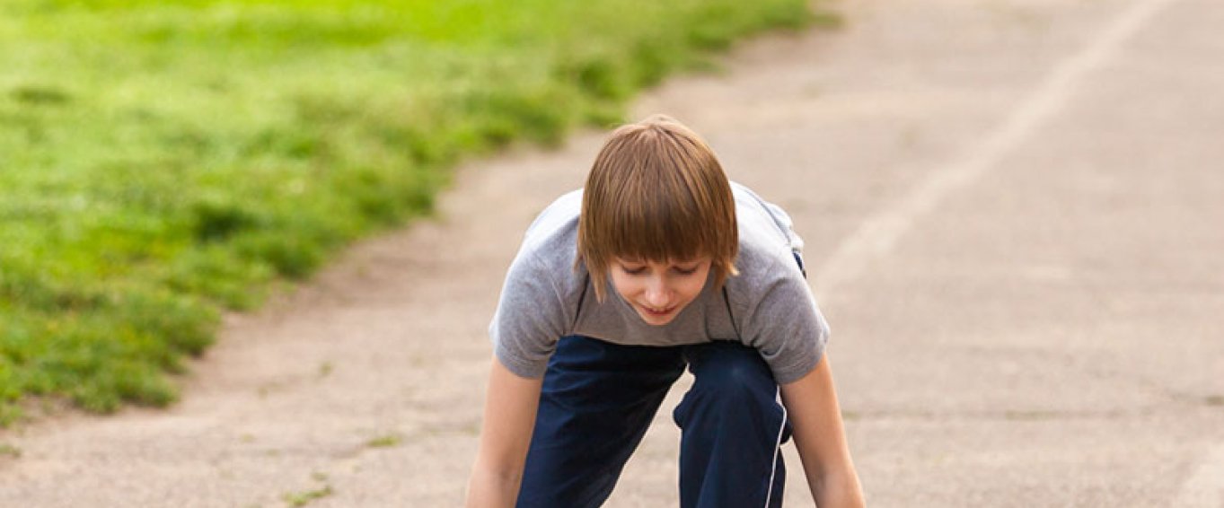Child about to start running on a track Child about to start running on a track
