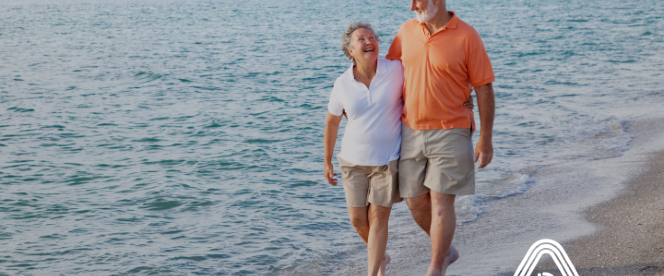 Older couple walking on beach