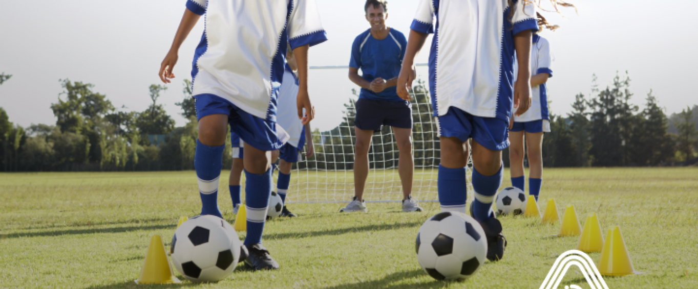 Children practising football skills in a field Children practising football skills in a field