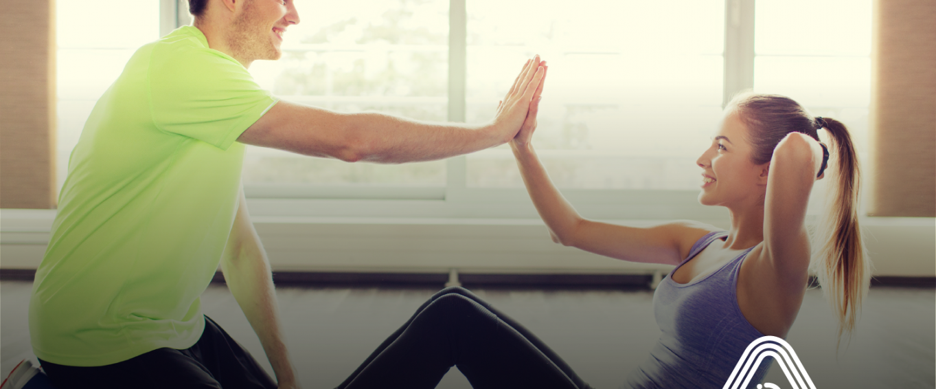 man and woman high fiving in gym man and woman high fiving in gym