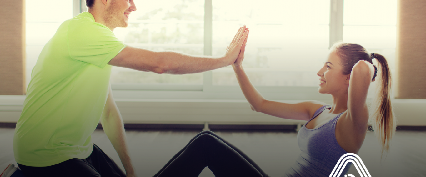 man and woman high fiving in gym