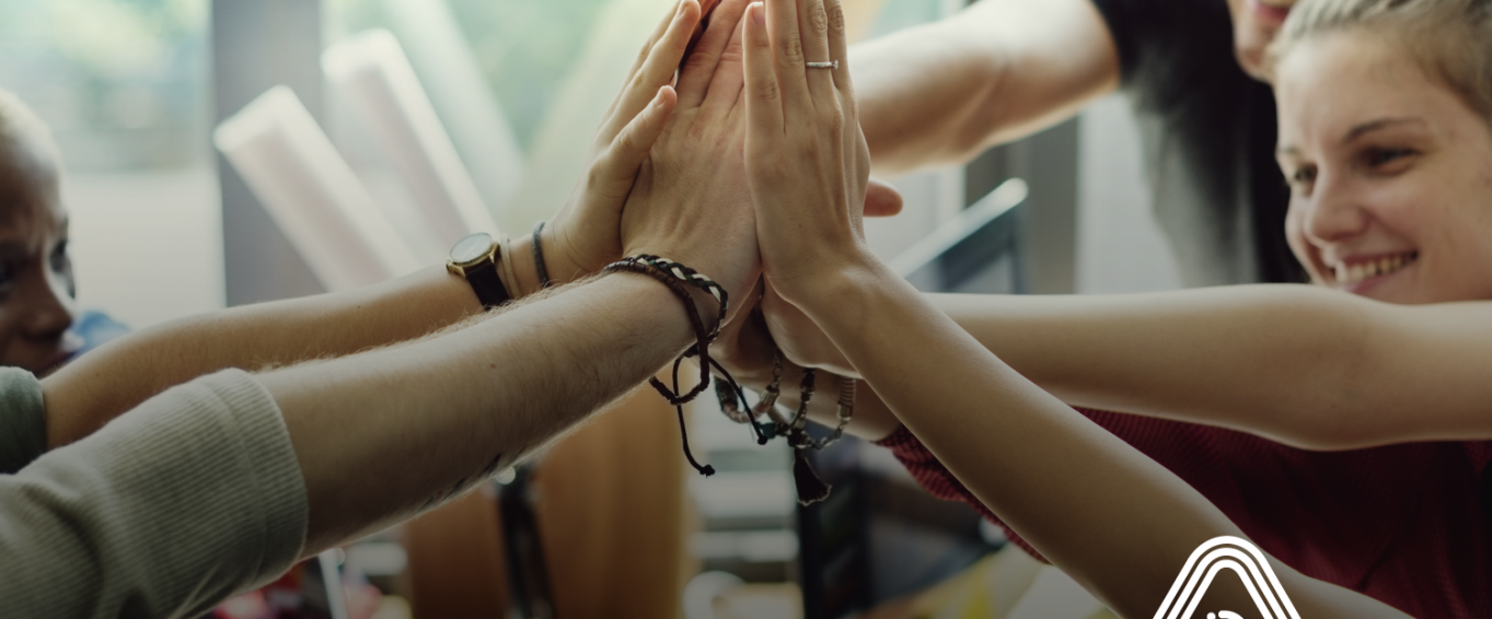 Group of people high fiving at desk