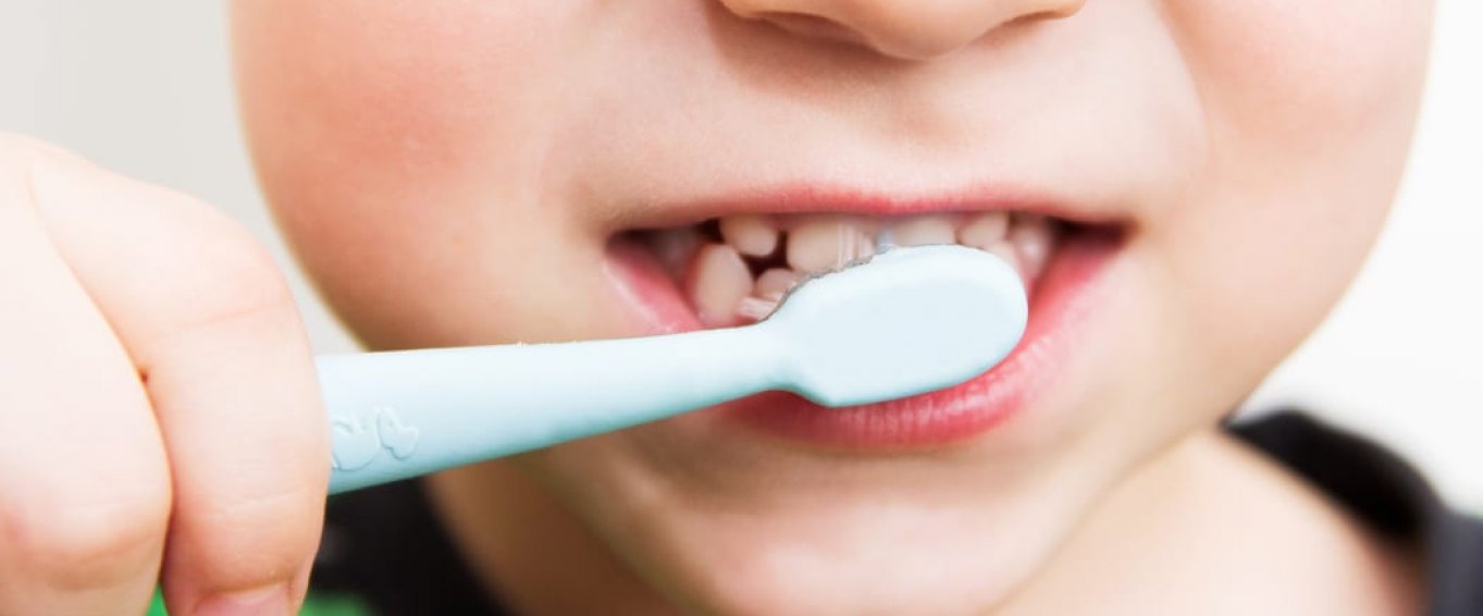 young boy's mouth with toothbrush