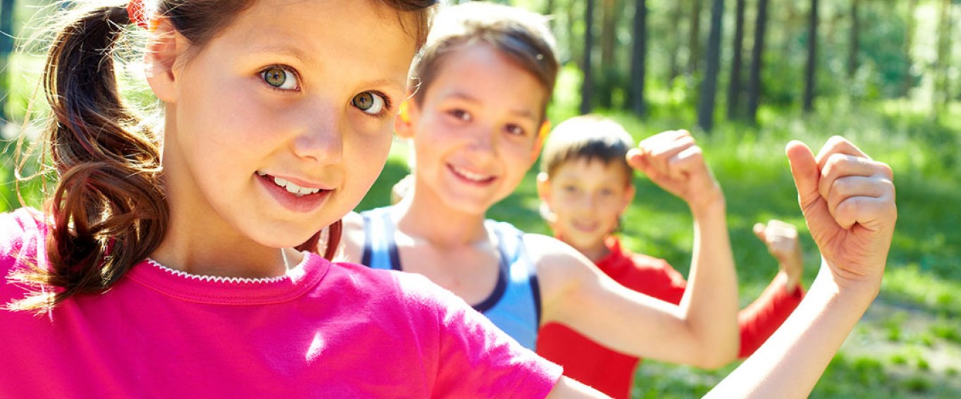 Three Children Flexing Their Biceps to Show Strength