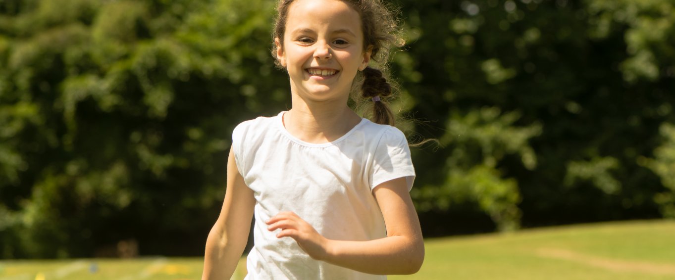 Young girl running and smiling outdoors Young girl running and smiling outdoors