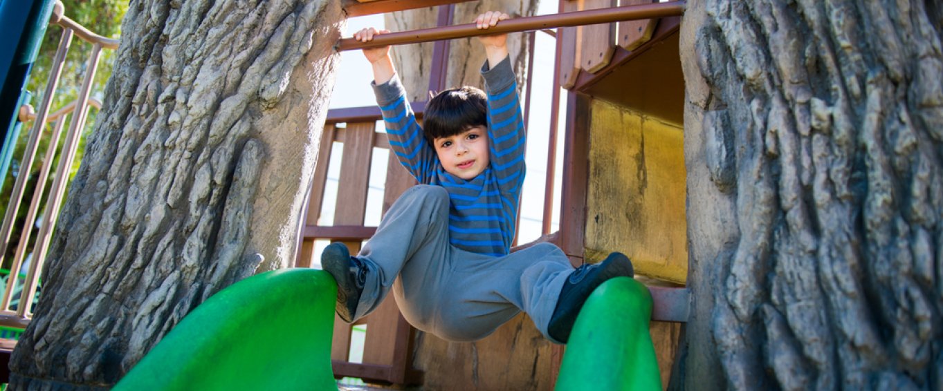 Little Boy Playing on a Slide