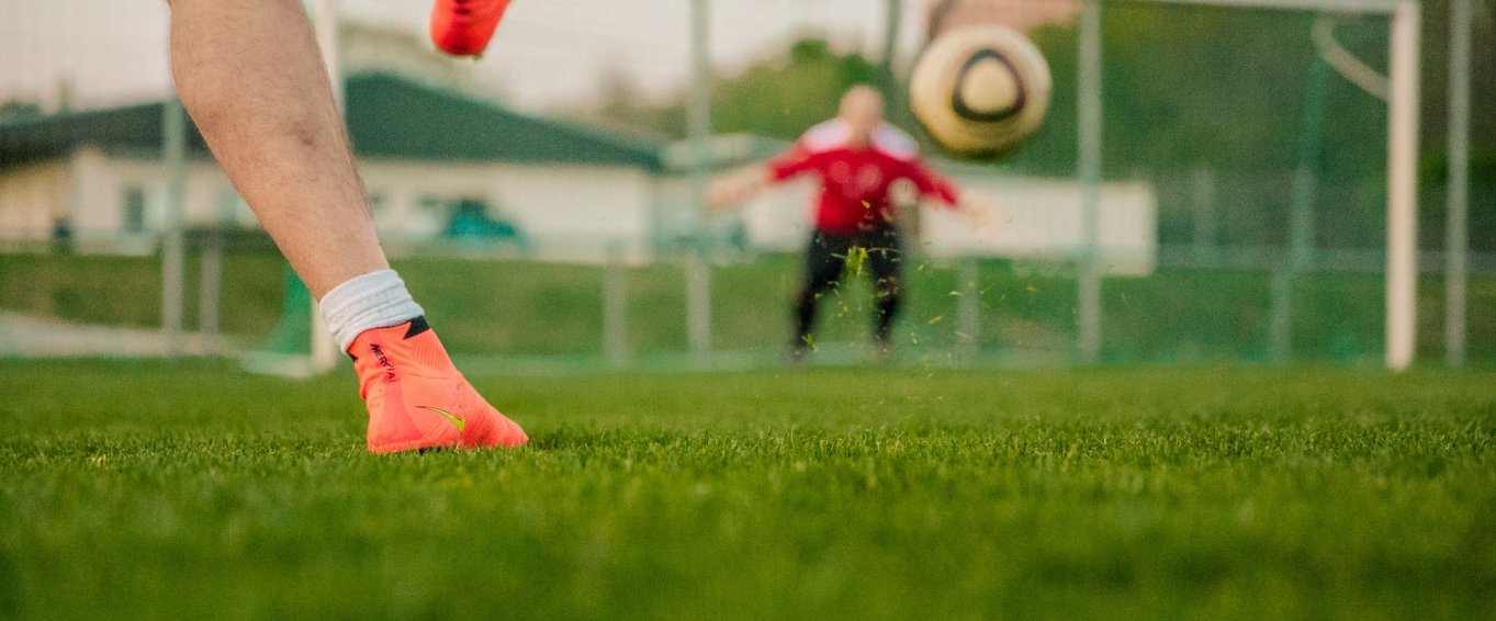 Boy Kicking Football at a Goalie Boy Kicking Football at a Goalie