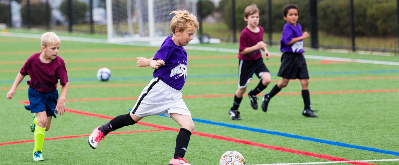 Four Young Boys Playing Football