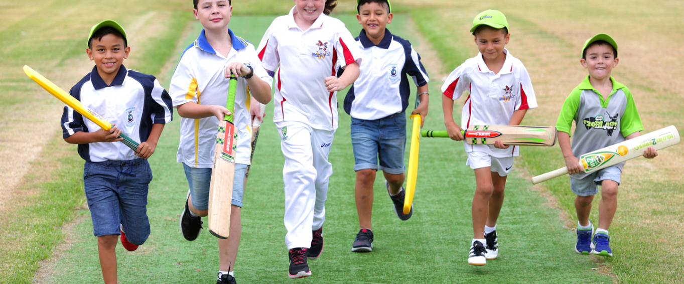 Six young boys running while holding cricket bats