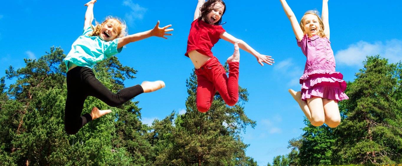 three young girls leaping into the air
