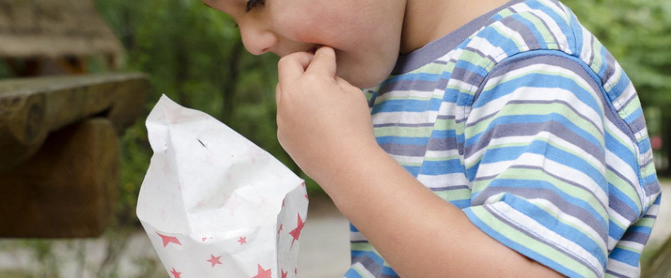 Child eating chips from a cone