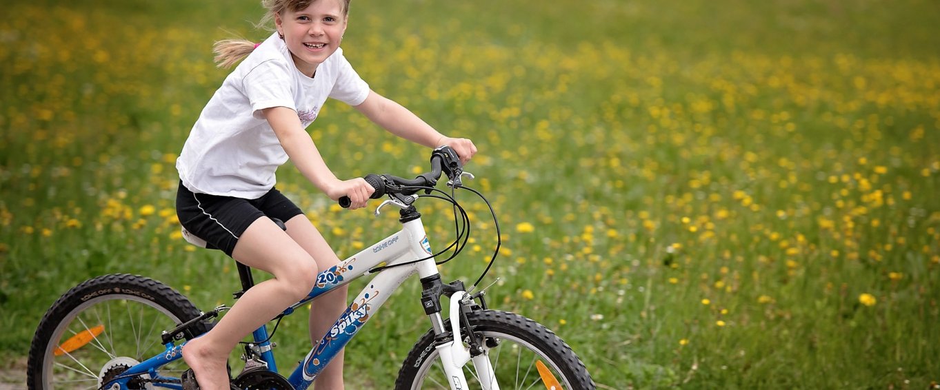 Young Girl Riding a Bicycle & Smiling