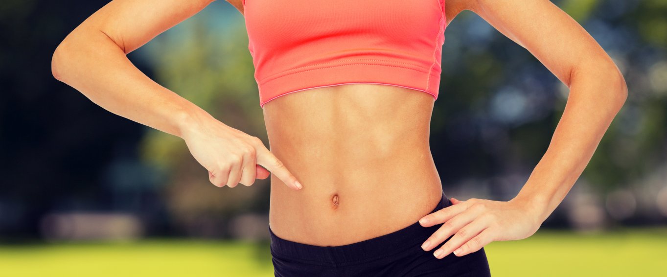 Athletic woman pointing to her stomach