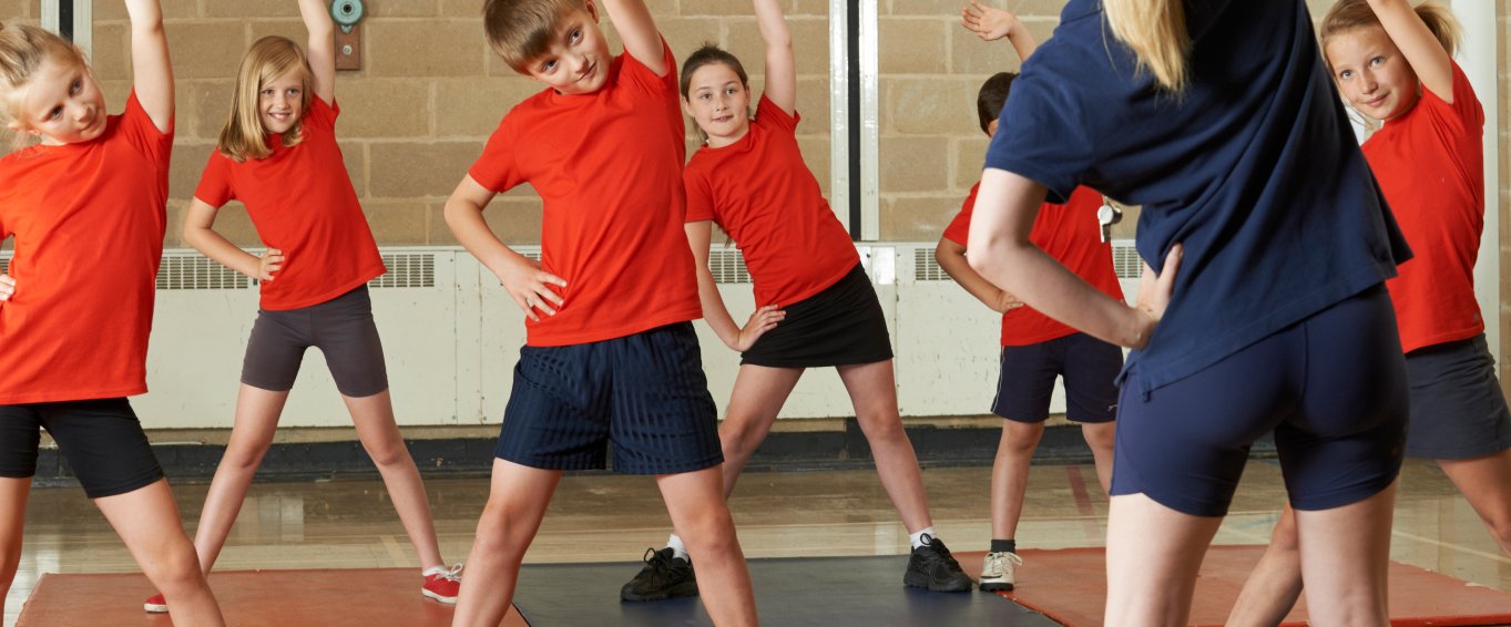 Young Children Stretching in Gym Class