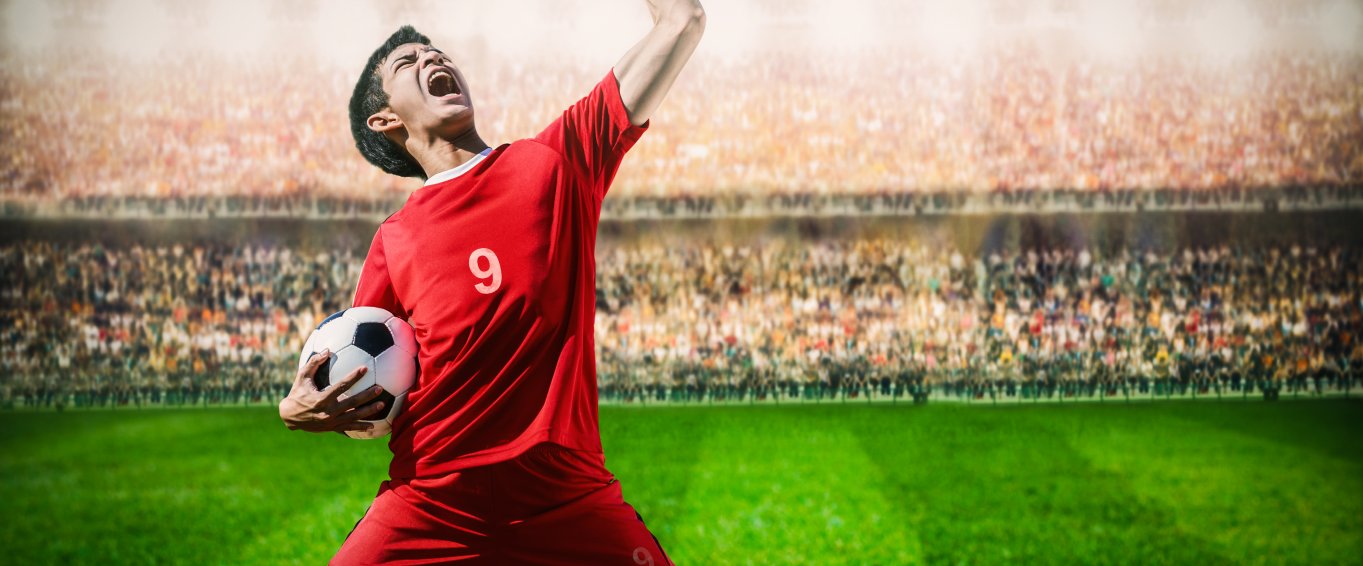 Male footballer celebrating goal infront of crowd Male footballer celebrating goal infront of crowd
