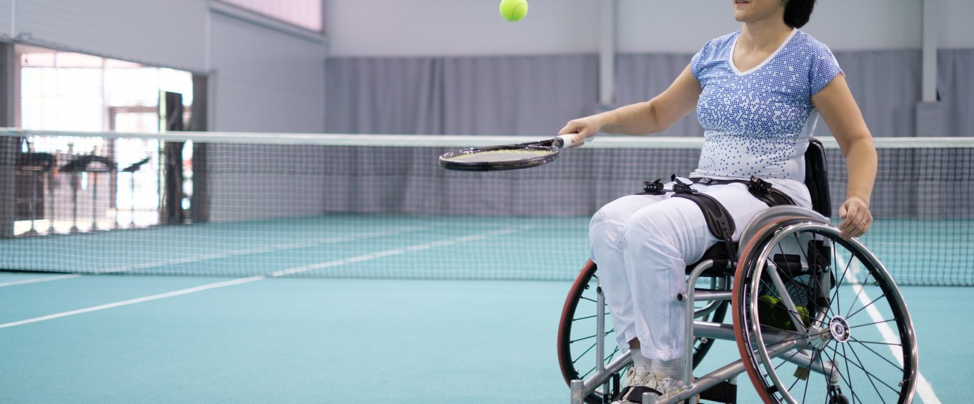 Woman in wheelchair playing tennis