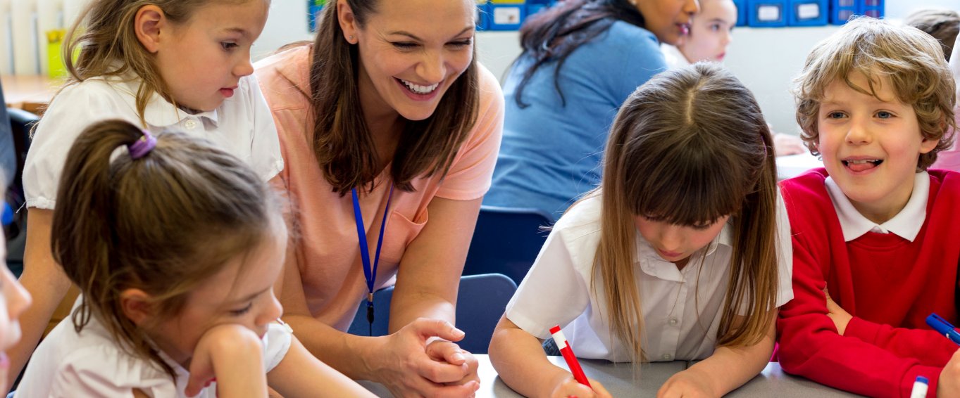 Smiling Teacher Looking at Her Pupils' Drawings