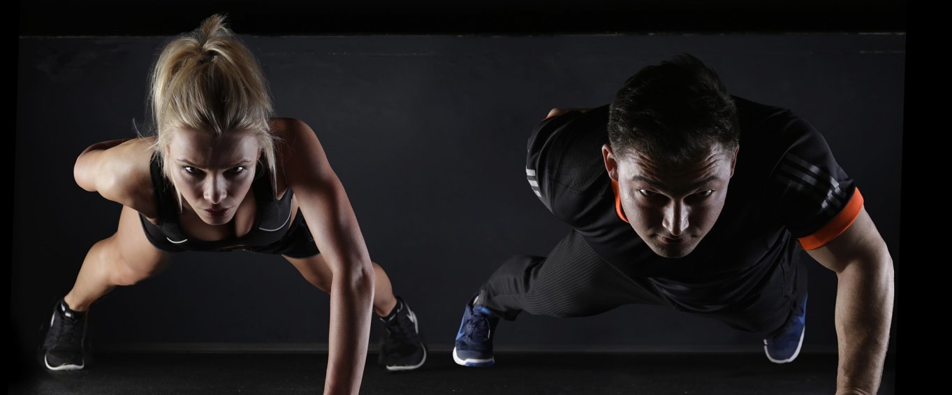 Two fitness models doing press ups