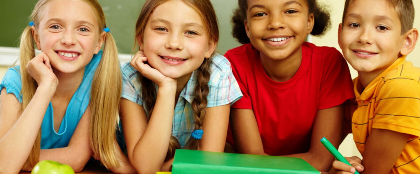 Four Smiling Children with Books and an Apple