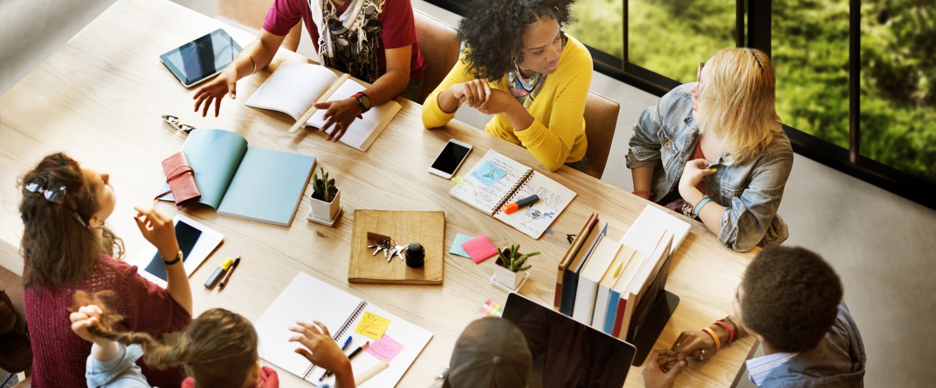 A Group of Teachers Brainstorming At a Desk A Group of Teachers Brainstorming At a Desk