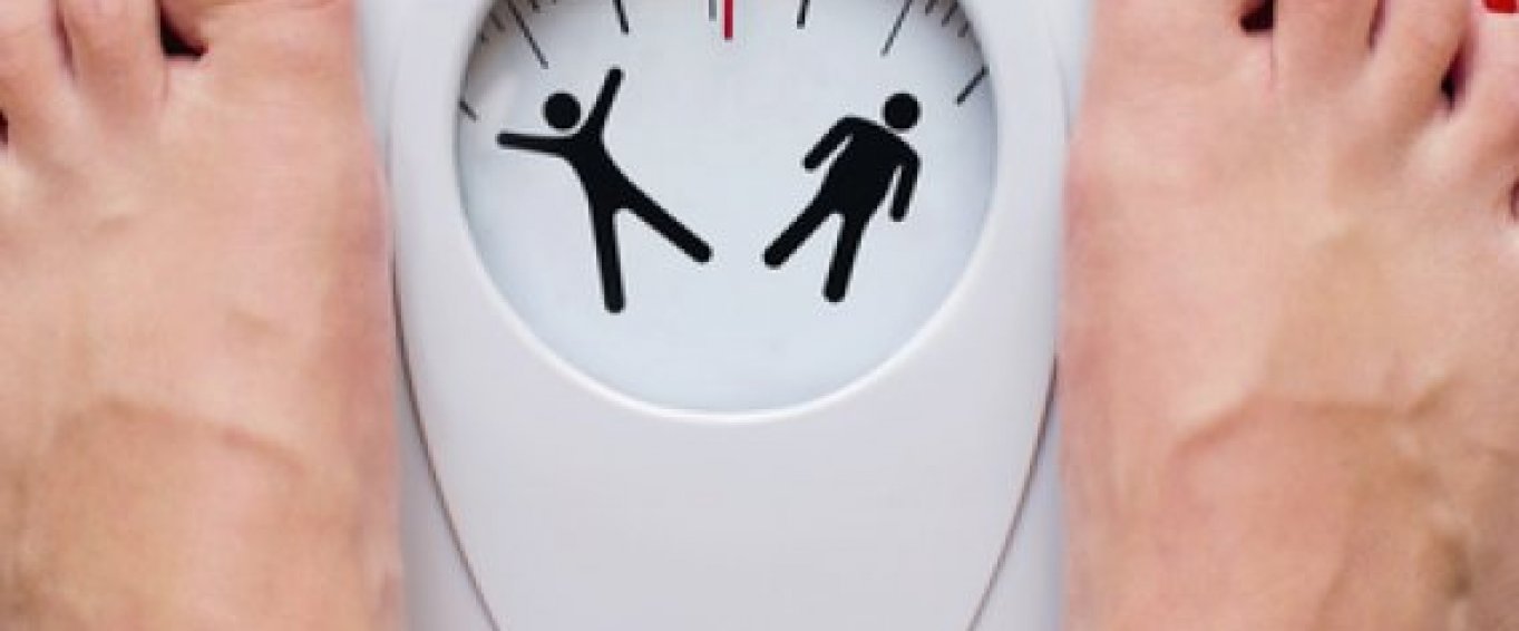 Woman weighing herself on a scale Woman weighing herself on a scale