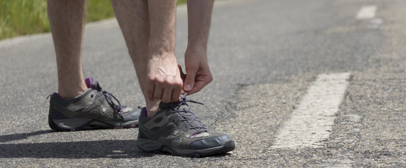 Man tying up running shoes