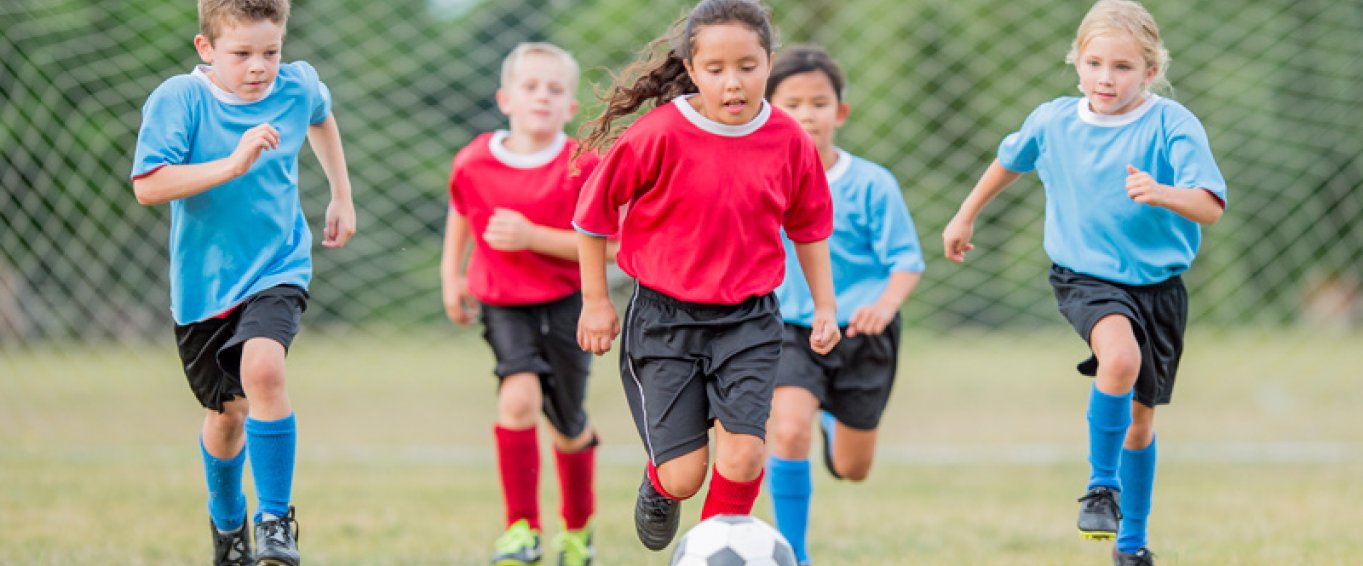 5 Children in Footie Kits Chasing a Football 