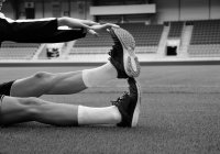 Footballer stretching out leg on football pitch