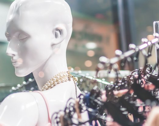 Mannequin in front of dresses