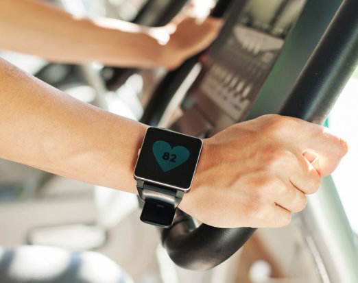 Man with a fitness tracker on an exercise bike