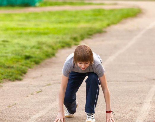 Child about to start running on a track