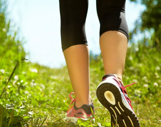 Woman in fitness clothes walking through a field