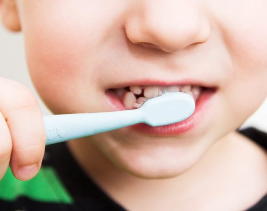 young boy's mouth with toothbrush