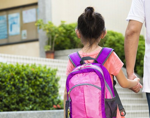 Girl with Pink Backpack Holding an Adult's Hand