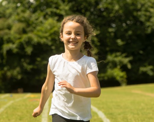 Young girl running and smiling outdoors