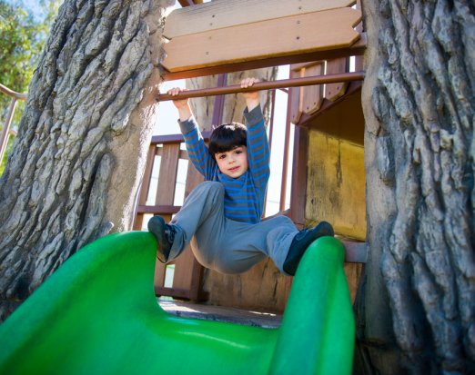 Little Boy Playing on a Slide