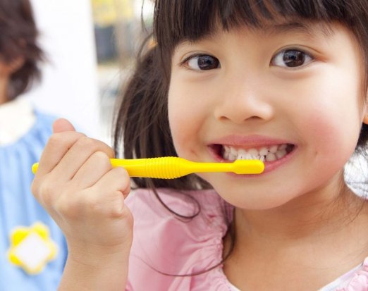 Young Girl Demonstrating Proper Toothbrushing Technique