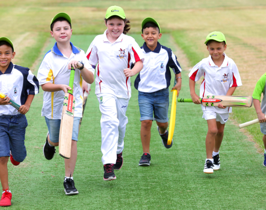 Six young boys running while holding cricket bats