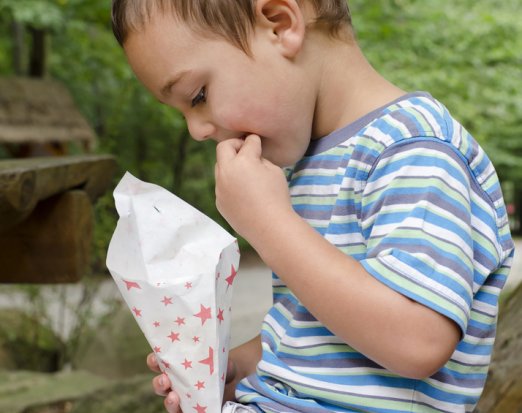 Child eating chips from a cone