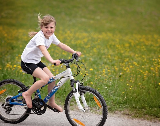 Young Girl Riding a Bicycle & Smiling