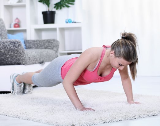 Woman doing pushups on a rug