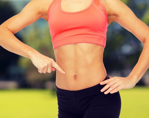 Athletic woman pointing to her stomach