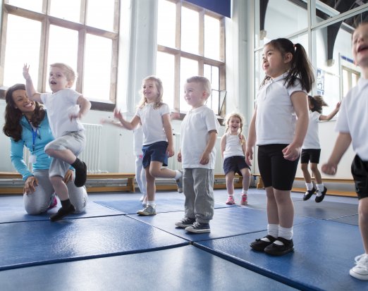 Primary School Pupils Exercising on Gym Mats