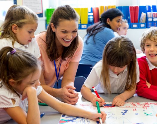 Smiling Teacher Looking at Her Pupils' Drawings